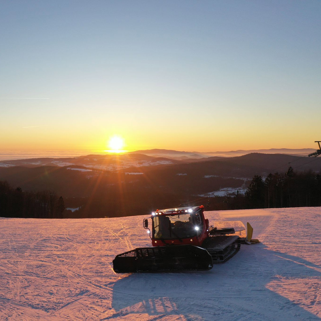Pistenbully bei Sonnenuntergang an der 6er-Sesselbahn in Mitterdorf